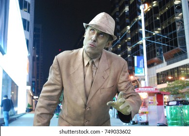 TORONTO, CANADA - October 27, 2017 - Gold Mime, Street Artist, Living Statue, Man Posing In Frozen Position And Will Only Move When Money Donation Is Given. Artist At Dundas Square, Downtown, At Night