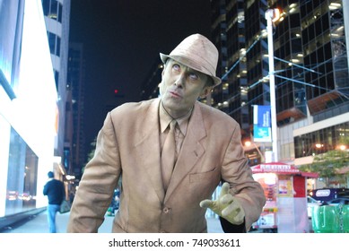 TORONTO, CANADA - October 27, 2017 - Gold Mime, Street Artist, Living Statue, Man Posing In Frozen Position And Will Only Move When Money Donation Is Given. Artist At Dundas Square, Downtown, At Night