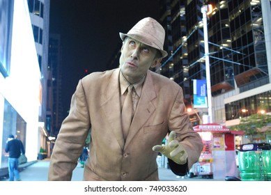 TORONTO, CANADA - October 27, 2017 - Gold Mime, Street Artist, Living Statue, Man Posing In Frozen Position And Will Only Move When Money Donation Is Given. Artist At Dundas Square, Downtown, At Night