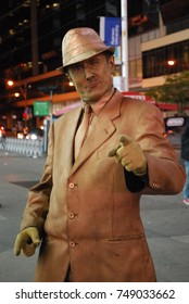 TORONTO, CANADA - October 27, 2017 - Gold Mime, Street Artist, Living Statue, Man Posing In Frozen Position And Will Only Move When Money Donation Is Given. Artist At Dundas Square, Downtown, At Night