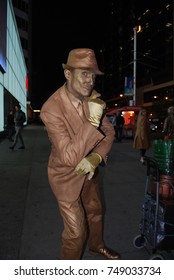 TORONTO, CANADA - October 27, 2017 - Gold Mime, Street Artist, Living Statue, Man Posing In Frozen Position And Will Only Move When Money Donation Is Given. Artist At Dundas Square, Downtown, At Night