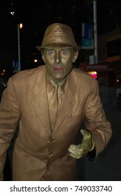 TORONTO, CANADA - October 27, 2017 - Gold Mime, Street Artist, Living Statue, Man Posing In Frozen Position And Will Only Move When Money Donation Is Given. Artist At Dundas Square, Downtown, At Night