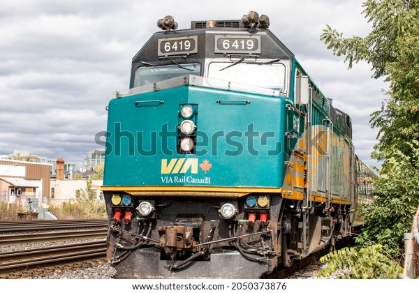 Toronto, Canada, September 30,\
2021; Close up head on view of a Canadian VIA Rail passenger\
railway diesel locomotive 6419 approaching Mimico from downtown\
Toronto.
