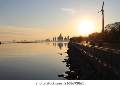 Toronto City Skyline With A Wind Turbine To The Side And Masked People Walking Outside