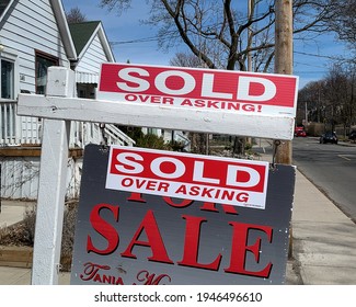 Toronto - March 30, 2021: During a hot real estate market a sign in front of a recently sold home displays that it recently, “sold over asking!”