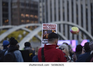 TORONTO - NOVEMBER 13: A Participant With A Sign Denouncing Trumps' Policy Towards Immigration And Welcoming Refugees To North America During A Protest Rally On November 13, 2016 In Toronto, Canada.