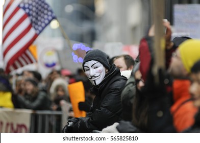 TORONTO - NOVEMBER 19: A protester wearing a "guy fawkes" mask standing among the crowd during a protest in front of Trump Tower on November  19, 2016 in Toronto, Canada.