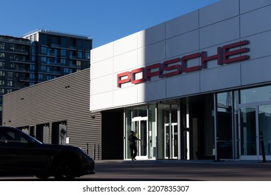 Toronto, ON, Canada - September 23, 2022: The Front Of A Porsche Dealer Is Seen In The Early Morning As A Man Walks In; Porsche Is A German High-performance And Luxury Auto Manufacturer.