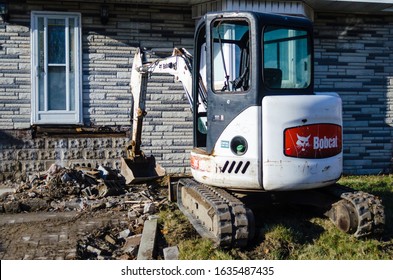 Toronto, ON/Canada - 1/20/2020: Compact Bobcat Excavator Working At The Front Of A House.