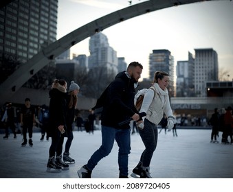 Toronto, Ontario, Canada- December 10th, 2021: A Couple Ice Skating At Toronto City Hall’s Nathan Phillips Square.