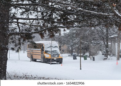 Toronto, Ontario, Canada, February 24, 2020: School Bus Covered In Snow During Heavy Snow Fall In Toronto Snow Day 