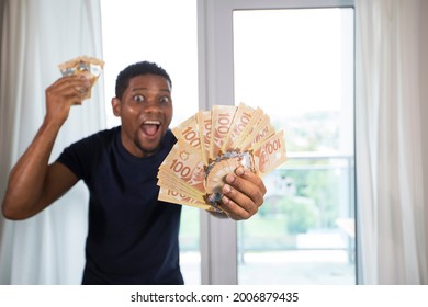 Toronto, Ontario, Canada - July 2021: Excited Man Holding Many Canadian One Hundred Dollar Bills, Paper Currency Payment. Camera Focuses On The Money.