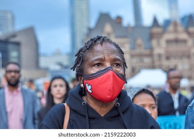 Toronto Ontario, Canada- May 19th, 2022: A Black Lady Wearing A Mask, While Listening To The Vigil About The Shooting In Buffalo New York At Toronto City Hall’s Nathan Philips Square.