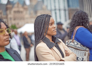 Toronto Ontario, Canada- May 19th, 2022: A Black Lady Listening To The Vigil About The Shooting In Buffalo New York, While  At Toronto City Hall’s Nathan Philips Square.