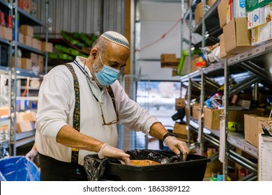 TORONTO, ONTARIO, CANADA - NOVEMBER 25, 2020: PEOPLE WORK AT JEWISH FOOD BANK, PREPARING FOOD FOR FAMILIES IN NEED OF HELP DURING COVID-19 PANDEMIC. 