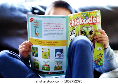 Toronto, Ontario, Canada: November 3, 2020 - Kid Reading His Favorite Chickadee Magazine At Home During Covid-19 Pandemic.  Sitting On Comfortable Sofa. Child Education, Self Learning Background.