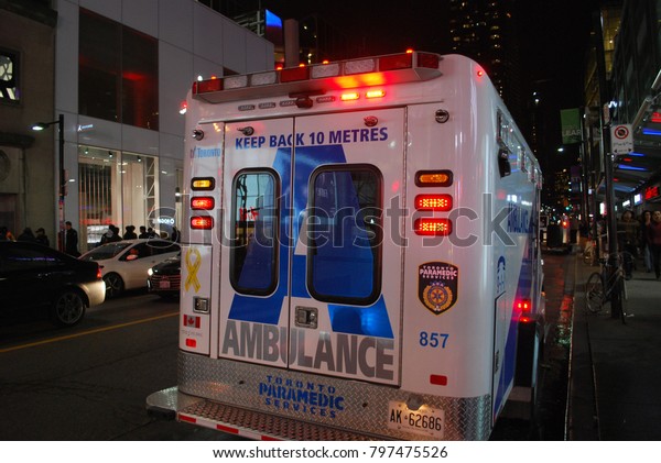 TORONTO, ONTARIO, CANADA - October 27 2017 -\
Ambulance At Dundas Square on Yonge Street, city, 911, Emergency,\
crash, Accident on the road, injuries, paramedics with stretcher,\
flashing lights, aid