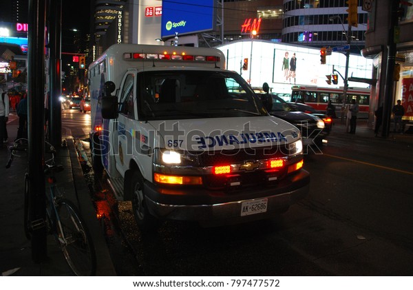 TORONTO, ONTARIO, CANADA - October 27 2017 -\
Ambulance on Yonge Street, city, 911, Emergency, car crash scene,\
Accident on the roads, injuries, paramedics with stretcher,\
flashing lights, aid,\
health\

