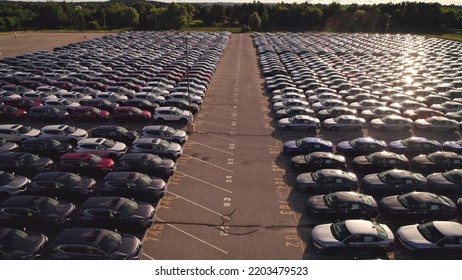 Toronto, Ontario, Canada – September 10, 2022: New Cars Located At The Factory Parking Lot Aerial View At Golden Hour. Car Manufactory Parking Area For A New Hybrid EV. Green Electric Vehicles.