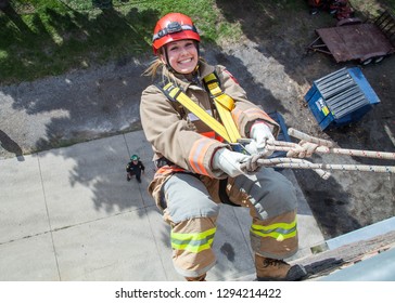 Toronto, Ontario/Canada - July 16, 2018: A Female Fire Fighter Cadet Learns How To Repel Down A Wall