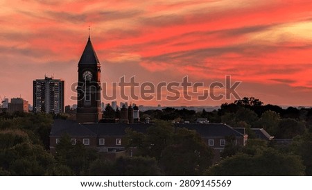 Toronto skyline at sunset with dramatic red clouds and historic clock tower silhouette in Ontario, Canada. Urban evening cityscape and travel destination concept.