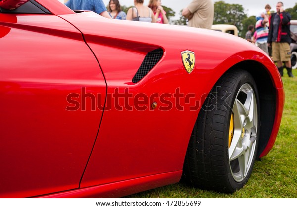 TORPOINT CORNWALL ENGLAND - 7 AUGUST, 2016: Hot red\
Ferrari 599 supercar side panel, brand and front wheel at the\
American and Custom Car Show Mount Edgcumbe House in Cornwall UK.\
Editorial Use Only.