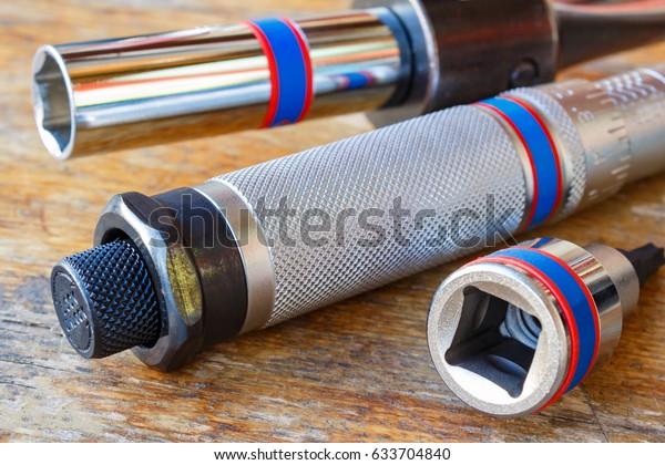 Torque wrench\
handle on a wooden table\
closeup