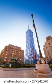 Torre Latinoamericana Or Tower Of Latino America And Other Buildings And Mexican Flag On Juarez Avenue And Morning Sun Flare, Mexico City Capital 