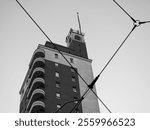 Torre Littoria skyscraper in Piazza Castello behind tramway wires in Turin, Italy in black and white