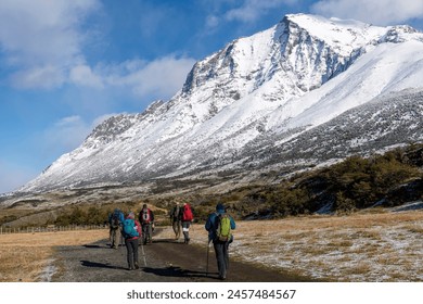 Torres del Paine National Park, Patagonia, Chile; hikers walking towards the lookout point for the three iconic granite towers (torres) on the W-trek route surrounded by snow covered mountains - Powered by Shutterstock