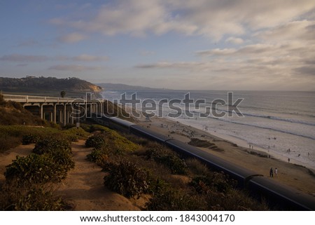Torrey Pine Beach and Highway 101 in Delmar, CA with Amtrak on evening with sunset and clouds