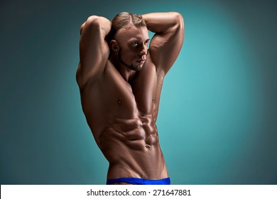 Torso Of Attractive Male Body Builder On Blue Background.