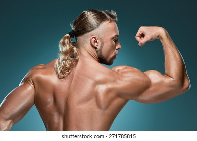 Torso Of Attractive Male Body Builder On Blue Background.