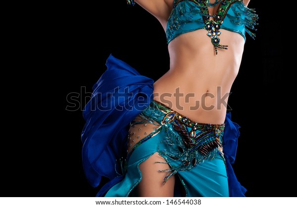 Torso of a\
female belly dancer wearing a teal blue costume and shaking her\
hips. Isolated on a black background.\
