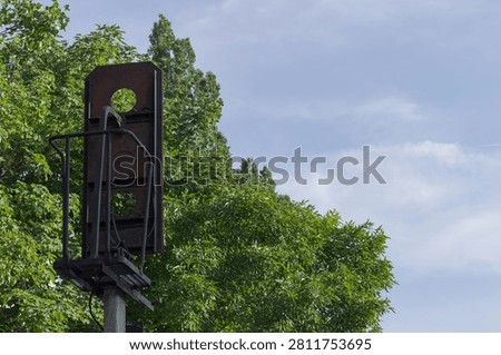 Torso of a railroad trafic light stands near the forest 