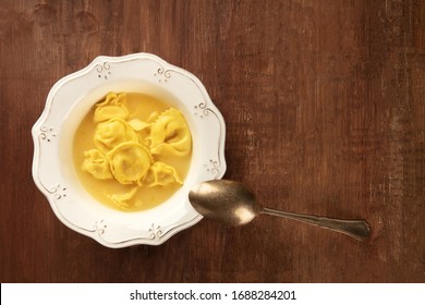 Tortellini Served With Broth, Overhead Shot On A Dark Rustic Wooden Background