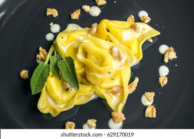 Tortelloni (typical Bologna homemade stuffed pasta) with nuts, cream and sage