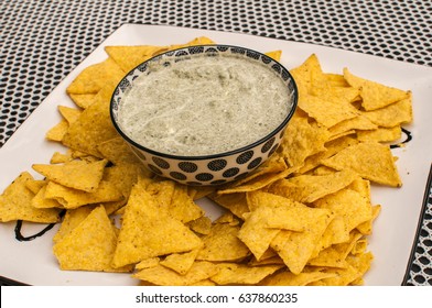 Tortilla Chips With Cheese And Spinach Dip Bowl On Covered Table Surface