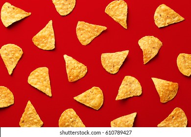 Tortilla Chips Pattern On A Red Background. Repetition Concept. Top View