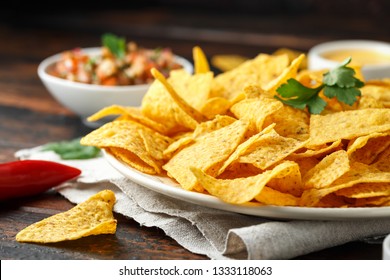 Tortilla nachos chips with cheese sauce, guacamole and tomatoes salsa dip. lime. chilli pepper. - Powered by Shutterstock