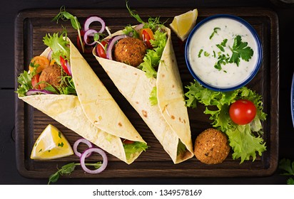 Tortilla wrap with falafel and fresh salad. Vegan tacos. Vegetarian healthy food. Top view