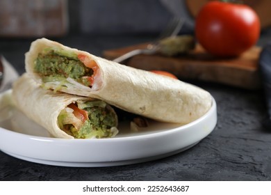 Tortilla wrap with falafel and fresh salad. Vegan tacos. Vegetarian healthy food. Falafel, Sandwich Falafel on a black background. 
 - Powered by Shutterstock