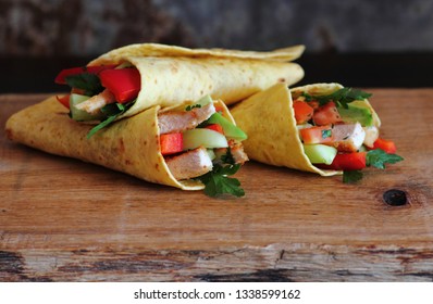 Tortilla Wraps With Grilled Chicken Meat And Fresh Vegtables On Wood Table