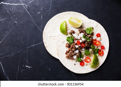 Tortillas Filled With With Ground Beef And Hot Chili Peppers On Dark Marble Background