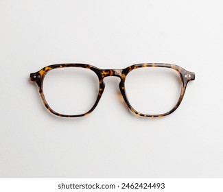 A tortoise plastic frame front with a double rivet cluster on the endpiece, isolated on white background. Full rim frame front types, the main part of glasses frame.