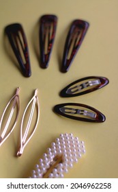 Tortoise Shell, Golden And Pearl Hair Accessories On Yellow Background. Selective Focus.