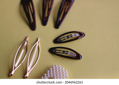 Tortoise Shell, Golden And Pearl Hair Accessories On Yellow Background. Selective Focus.