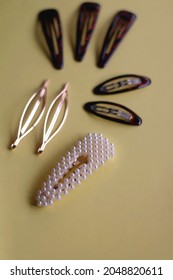 Tortoise Shell, Golden And Pearl Hair Accessories On Yellow Background. Selective Focus.