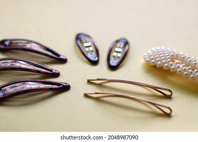 Tortoise Shell, Golden And Pearl Hair Accessories On Yellow Background. Selective Focus.