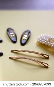 Tortoise Shell, Golden And Pearl Hair Accessories On Yellow Background. Selective Focus.